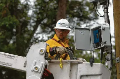  ?? Houston Chronicle file ?? CenterPoin­t Energy’s Mike Lindemann works on a cell relay transmitte­r, which sends energy usage data from businesses or residences to the CenterPoin­t network.