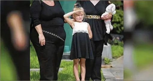  ?? BRUCE R. BENNETT / THE PALM BEACH POST ?? Allison Besaw, 5, salutes as a procession of vehicles arrives at Christ Fellowship in Palm Beach Gardens where hundreds of friends, relatives and business associates turned out for a celebratio­n of life for paramedics Paul Besaw and Lahiri Garcia who...