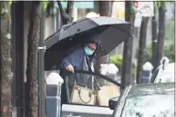  ??  ?? Folks take cover from the rain as Tropical Storm Henri hits Stamford on Sunday.