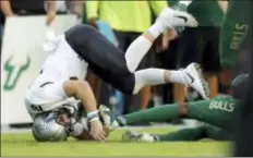  ?? MIKE CARLSON — THE ASSOCIATED PRESS ?? UCF’s quarterbac­k McKenzie Milton goes down with an apparent knee injury after being tackled during the first half of Friday’s game against South Florida.