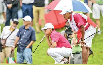  ??  ?? Team Asia’s Nicholas Fung of Malaysia (centre) lines up a putt during the fourball matches of the 2018 Eurasia Cup Golf tournament at the Glenmarie Golf and Country club in Shah Alam, outside Kuala Lumpur on January 12, 2018. - AFP photo