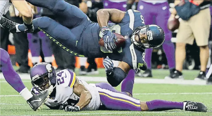  ?? STEPHEN BRASHEAR / AP ?? Una acción contundent­e entre Jabari Price (24) y Marcus Lucas (85), en el partido de la NFL entre los Minnesota Vikings y los Seattlle Seahawks, el viernes en Seattle