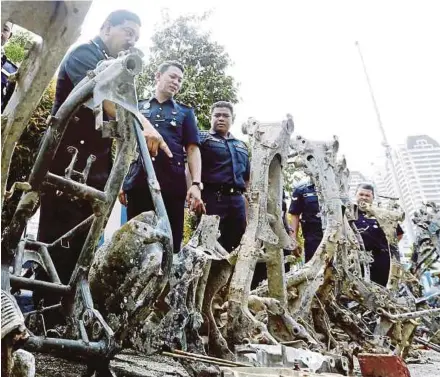  ?? PIC BY MIKAIL ONG ?? Assistant Commission­er Anuar Omar (left) with some of the motorcycle frames found after arresting five members of the ‘Pak Tam’ motorcycle theft gang.