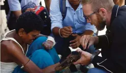  ??  ?? KATHMANDU: This photo shows Disaster Hack founder Matthew Rockwell, right, attaching a 3D printed prosthetic hand to leprosy sufferer Ram’s arm in Kathmandu. —AFP photos