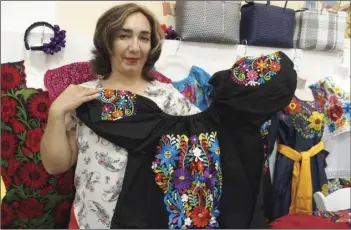  ??  ?? Betty Torres runs her mother’s cultural clothing booth at the 28th annual Mariachi Festival opening reception at the Carmen Durazo Cultural Arts Center on Wednesday. The clothes are made by the hands of indigenous women around Mexico, including Jalisco, Michoacan, Veracruz and Chiapas. PHOTO ANDY VELEZ