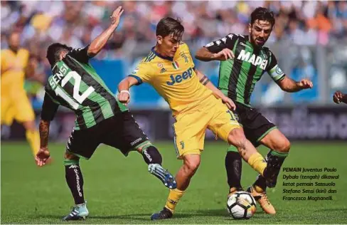  ??  ?? PEMAIN Juventus Paulo Dybala (tengah) dikawal ketat pemain Sassuolo Stefano Sensi (kiri) dan Francesco Magnanelli.