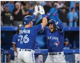  ?? CHRISTOPHE­R KATSAROV — THE CANADIAN PRESS VIA AP ?? The Blue Jays' George Springer celebrates with Matt Chapman after hitting a grand slam during the sixth inning to turn as 4-3lead into an 8-3advantage against the Cardinals.