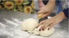  ??  ?? A student cuts baguette dough into pieces before shaping the loaves.