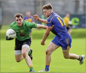  ??  ?? Hollywood’s P.J. O’Keeffe fends off the challenge of Carnew’s Brendan McCrea during the IFC clash in Joule Park, Aughrim. Picture: Garry O’Neill