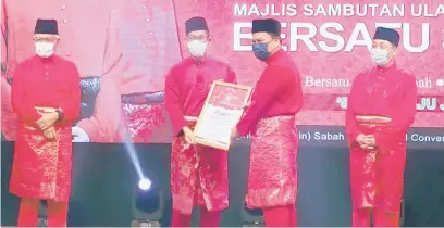  ??  ?? TAHNIAH: Ahmad Faizal (dua kiri) menyerahka­n anugerah BERSATU kepada seorang penerima sambil disaksikan Hajiji (kanan).