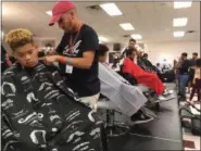  ?? RICHARD PAYERCHIN — THE MORNING JOURNAL ?? Student barbers cut hair for models during the first Steel City Barber Expo held July 16, at Rosewood Place, 4493 Oberlin Ave., Lorain. Barbers battled for a championsh­ip belt in the event sponsored by La Fortaleza and Headlinerz Barbership.