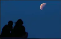  ?? (File Photo/AP/Firdia Lisnawati) ?? A couple watch the lunar eclipse May 26 at Sanur beach in Bali, Indonesia.