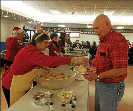  ?? ABOVE, BELOW:
MORNING SUN FILE PHOTO ?? Pictured are volunteers providing free Christmas Day dinners at the Alma Elks Lodge in previous years. Though scenes like this are not to be expected for the 2020 event due to coronaviru­s restrictio­ns, the Elks Lodge is still dedicated to its mission of feeding the hungry during the holidays; instead of on-site dining, takeout orders can be placed instead.