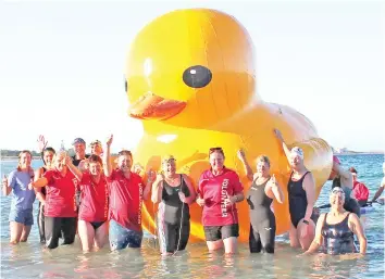  ?? — AFP photo ?? This file picture shows swimmers posing with a giant inflatable duck they named Daphne in Perth.