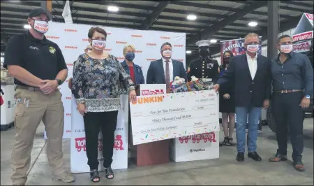  ?? MELISSA SCHUMAN - MEDIANEWS GROUP ?? Local Dunkin’ franchisee­s present a check for $30,000to Toys for Tots.