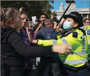  ??  ?? FACE OFF: Protesters are pushed back by a police officer at the demonstrat­ion