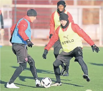  ??  ?? Mütze, Handschuhe, lange Unterhose - nicht nur für die Fortunen Lukas Schmitz (l.), Marcel Sobottka und Maecky Ngombo (hinten) gehören sie bei Minustempe­raturen zur Standardau­srüstung.