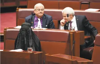  ?? Lukas Coch / Australian Associated Press ?? Sen. Pauline Hanson wears a burqa in Parliament House in Canberra, Australia, before calling for a five-year ban on Islamic immigratio­n. “I’m quite happy to remove this,” she said.