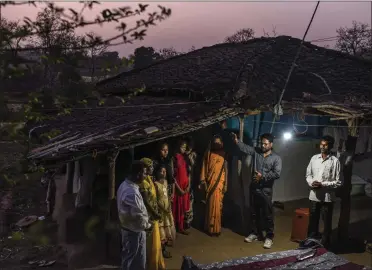  ?? ATUL LOKE FOR
THE NEW YORK TIMES ?? Vinod Patil, arm raised, a Pentecosta­l preacher, prays for a family at their home in the state of Madhya Pradesh, India, in 2021. In a country with more than 30 million Christians nationwide, antiChrist­ian vigilantes are sweeping through villages, storming churches, burning literature, attacking schools and assaulting worshipers, and In many cases the police and members of India's governing party are helping them.