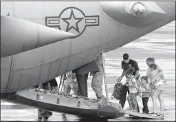  ??  ?? Paisley Golden (right photo) comforts her sister Poppy on Monday as they arrive at Scholes Internatio­nal Airport in Galveston, Texas, for an evacuation flight on a Texas Air National Guard transport plane. Then they boarded with their mother, Sara...