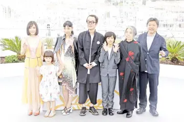  ??  ?? Director Hirokazu Kore-eda (right) with cast members Kirin Kiki, Jyo Kairi, Lily Franky, Sakura Ando, Miyu Sasaki, Mayu Matsuoka during a photocall for the film ‘Shoplifter­s’ at the 71st Cannes Film Festival in Cannes, France. • (Right) Kore-eda reacts...