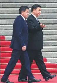  ?? PHOTOS BY XU JINGXING, FENG YONGBIN / CHINA DAILY ?? President Xi Jinping escorts visiting Kyrgyz President Sooronbay Jeenbekov at the Great Hall of the People (left), where a welcoming ceremony with new uniforms and formations debuted on Wednesday (right).