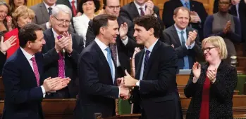  ?? ADRIAN WYLD / THE CANADIAN PRESS ?? Prime Minister Justin Trudeau shakes hands with Finance Minister Bill Morneau on Wednesday following the fiscal economic update in the House of Commons, which featured tax changes to encourage business investment.