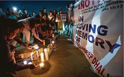  ?? Mark Mulligan / Staff photograph­er ?? People light candles after a vigil Monday for Harris County Sheriff’s Office Deputy Sandeep Dhaliwal.