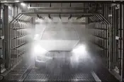  ?? JASPER JUINEN / BLOOMBERG 2016 ?? A Tesla Model X SUV undergoes rain testing during assembly for the European market in 2016 at the Tesla factory in Tilburg, Netherland­s. Right now, however, Tesla has no more important product than the new Model 3 midsize sedan.