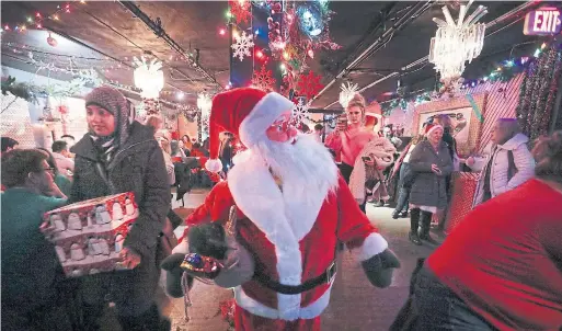  ?? RICHARD LAUTENS PHOTOS TORONTO STAR ?? A lifelike Santa mannequin in the centre of the room. “The whole atmosphere is super friendly,” the bartender, Girard, says. “We get 19-year-olds to grandparen­ts.”