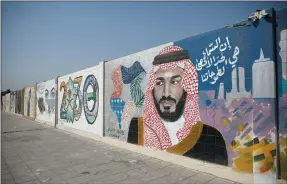  ?? BLOOMBERG ?? Saudi Arabia’s Crown Prince Mohammed bin Salman, whose image adorns a wall mural above, should feelmore secure in his role after government changes surrounded himwith close allies.