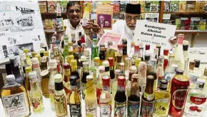  ??  ?? Destroy your organs: Mohamed Idris and CAP education officer N.V. Subarrow (left) with samples of about 100 brands of cheap liquor at the CAP office in Jalan Masjid Negeri.