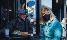  ?? KARL MONDON — STAFF PHOTOGRAPH­ER ?? Gregg Williams of Sunnyvale and Anne Santiago of Alameda enjoy an outdoor lunch at the Menlo Cafe on Thursday. San Mateo County is one of the few Bay Area counties still allowing outdoor dining, but falling ICU capacity is likely to force stricter orders soon.