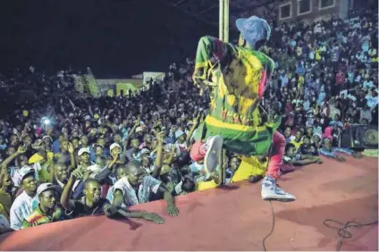  ??  ?? Rebel music: Zimdanceha­ll gets the crowds jumping at a concert in Zimbabwe. Photo: Cynthia R Matonhodze