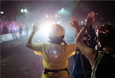  ?? Mason Trinca/The New York Times ?? Federal officers clash with protesters early Tuesday in Portland, Ore.