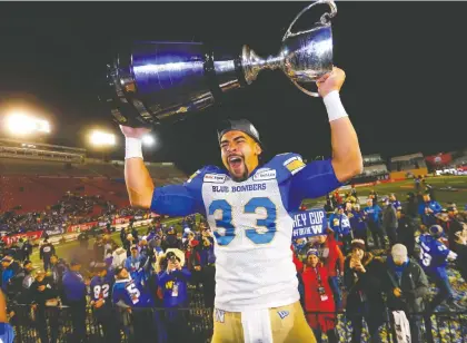  ?? DARREN MAKOWICHUK ?? Blue Bombers’ Andrew Harris hoists the Grey Cup after Winnipeg’s 33-12 win over the Hamilton Tiger-cats in Calgary on Sunday.