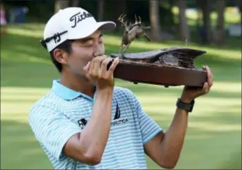  ?? CHARLIE NEIBERGALL — THE ASSOCIATED PRESS ?? Michael Kim kisses the trophy after winning the John Deere Classic golf tournament, Sunday at TPC Deere Run in Silvis, Ill.