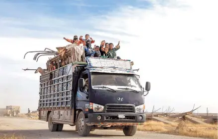  ?? AFP ?? Otra infancia. Un grupo de niños saludan desde el camión que los rescata de la zona controlada por los yihadistas del Estado Islámico, cerca de la ciudad de Mazraat Khaled, a 40 kilómetros de Raqqa, que supo ser el bastión del grupo terrorista.