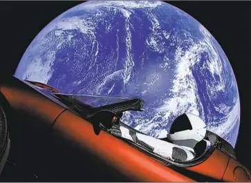  ?? SpaceX ?? A SPACEX spacesuit sits in a red Tesla sports car that was launched into space last year during the test f light of the Falcon Heavy rocket in an image taken from video. Elon Musk controls both Tesla and SpaceX.