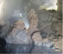  ??  ?? A caver ponders a safe way to ford a river inside Hang Son Đoòng.