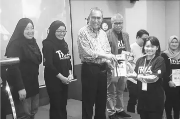  ??  ?? Len (centre) presenting certificat­es of participat­ion to a representa­tive of the students. Looking on is Awangku Merali (fourth right) and others.