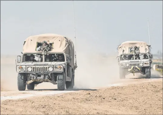  ?? Amir Levy Getty Images ?? Israeli military vehicles move along the border with the Gaza Strip on Wednesday. The Israeli government is participat­ing in talks with foreign mediators to achieve a temporary cease-fire with Hamas and a deal to release Israeli hostages held in Gaza.