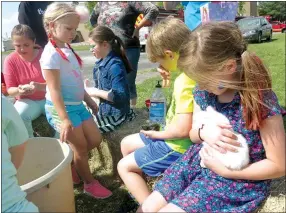  ?? Photo by Susan Holland ?? The petting zoo at the OCH Easter Eggstravag­anza attracted many youngsters who were eager to hold the fluffy chicks and soft bunnies.