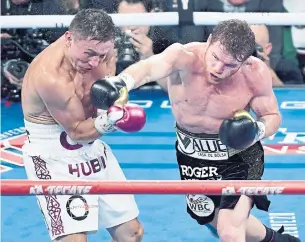  ?? ETHAN MILLER GETTY IMAGES FILE PHOTO ?? Canelo Alvarez, landing a right in a bout with Gennady Golovkin in September, landed a long-term deal worth $365 million (U.S.) afterward, catching Floyd Mayweather, below, off guard.