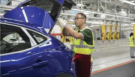  ?? BLOOMBERG PIC ?? An employee assembles a Jaguar E-Pace compact sport utility vehicle in Changshu, China. Tata Motors Ltd’s net loss was 270 billion rupees in the three months through December.