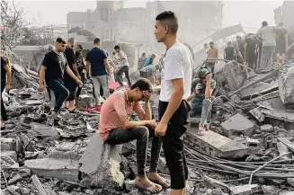  ?? ?? Palestinia­ns look for survivors following Israeli airstrike in Nusseirat refugee camp Tuesday.