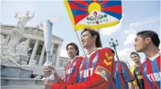  ?? FOTO: DPA ?? Spieler der tibetische­n Fußballnat­ionalmanns­chaft bei einem Fackellauf in Wien.