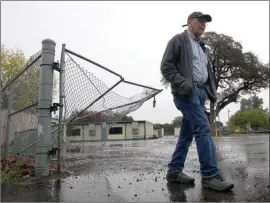  ?? The Associated Press ?? Randy Morehouse, the maintenanc­e and operations supervisor for the Corning Elementary School District, walks past the gate at Rancho Tehama Elementary School on Wednesday that a gunman crashed through a day earlier.