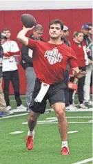  ?? MARK STEWART / MILWAUKEE JOURNAL SENTINEL ?? Wisconsin’s Tanner Mordecai throws a pass as teammates and NFL scouts watch during the Badgers’ pro day on Friday at the McClain Center in Madison.