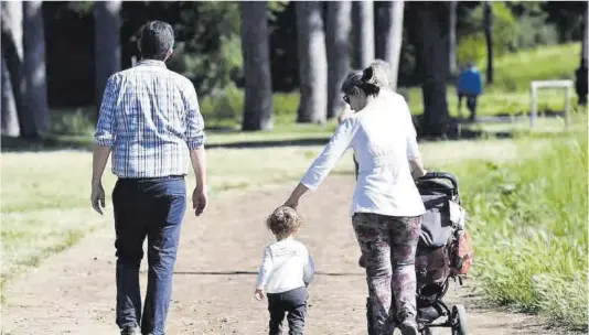  ?? Ettore Ferrari / Efe ?? Una pareja marcha de paseo con su hijo pequeño.